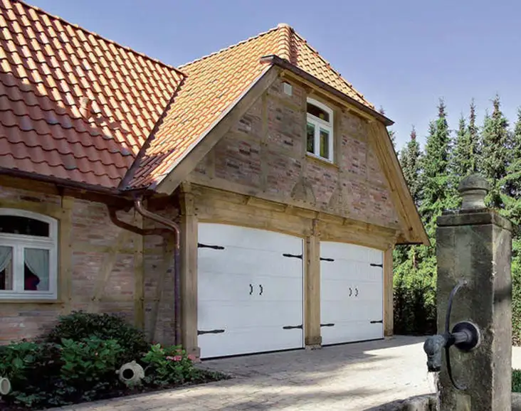 Große Garage mit zwei Sektionaltoren von Almtor von einem renovierten Bauernhaus