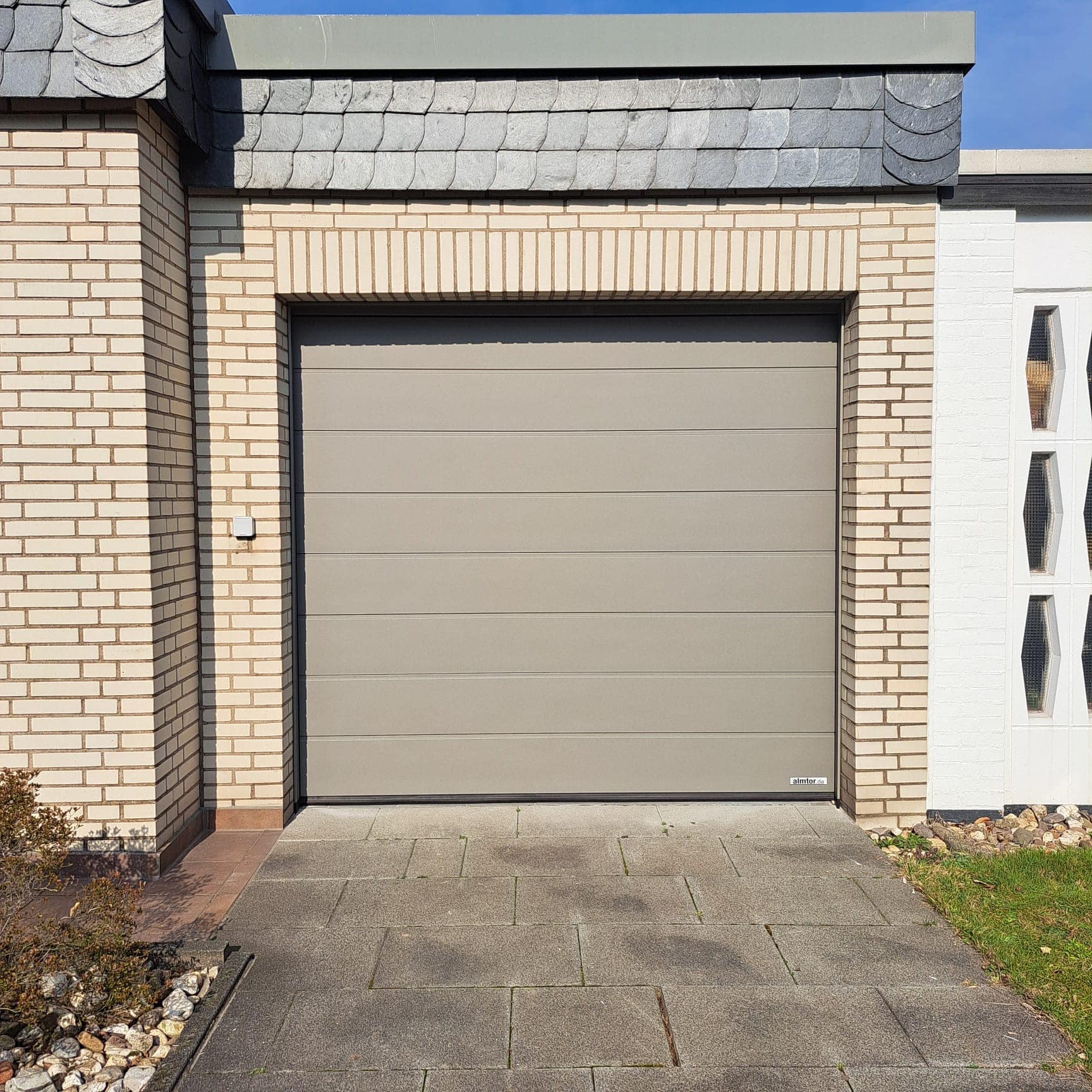 Beiges modernes Hörmann Garagentor am privaten Wohnhaus montiert von alm-Tor