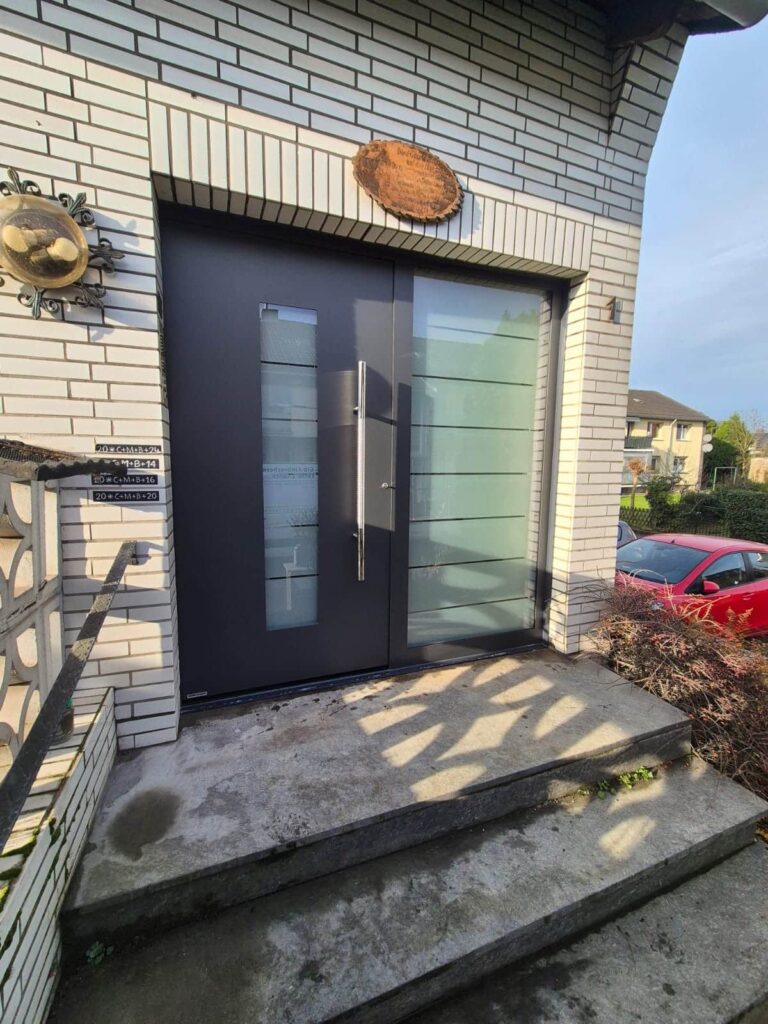 Moderne schwarze Haustür mit Milchglaseinsatz für private Häuser